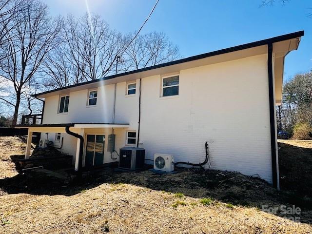 back of house with ac unit and central AC