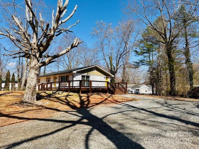 view of front of house featuring a deck and dirt driveway