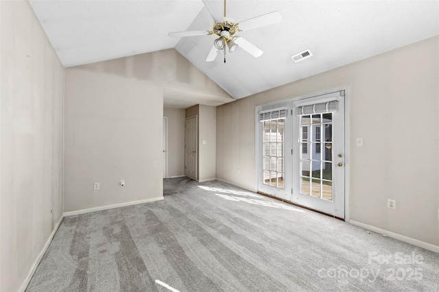 carpeted empty room featuring ceiling fan, lofted ceiling, visible vents, and baseboards