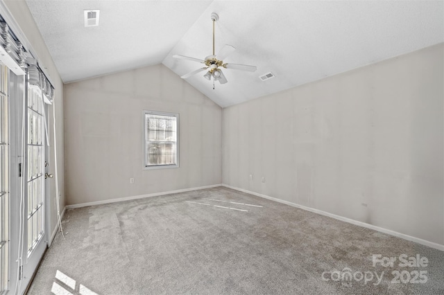 unfurnished bedroom featuring carpet, visible vents, vaulted ceiling, and ceiling fan