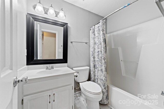 bathroom with marble finish floor, shower / tub combo with curtain, toilet, vanity, and a textured ceiling