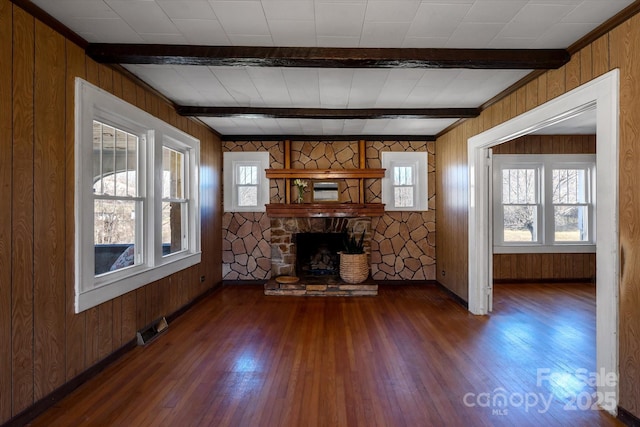 unfurnished living room featuring a fireplace, beamed ceiling, visible vents, and hardwood / wood-style floors