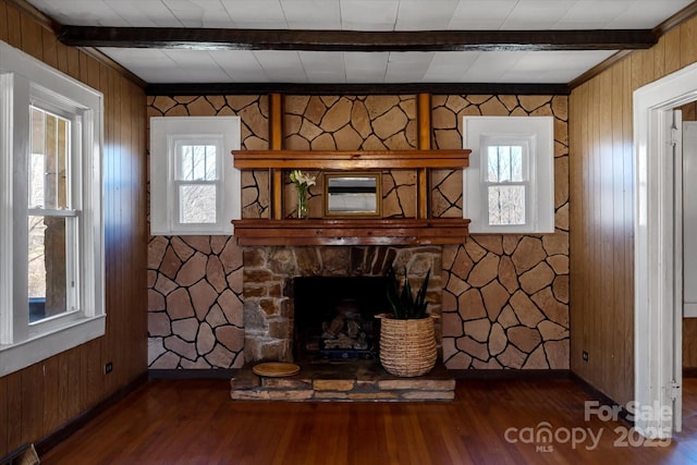 living room featuring beam ceiling, a fireplace, baseboards, and wood finished floors