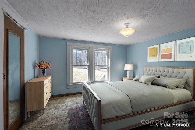 carpeted bedroom featuring a textured ceiling and baseboards