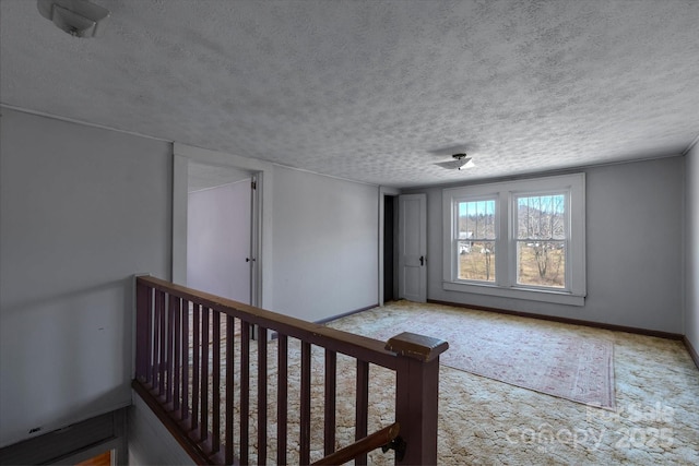 interior space featuring a textured ceiling and baseboards