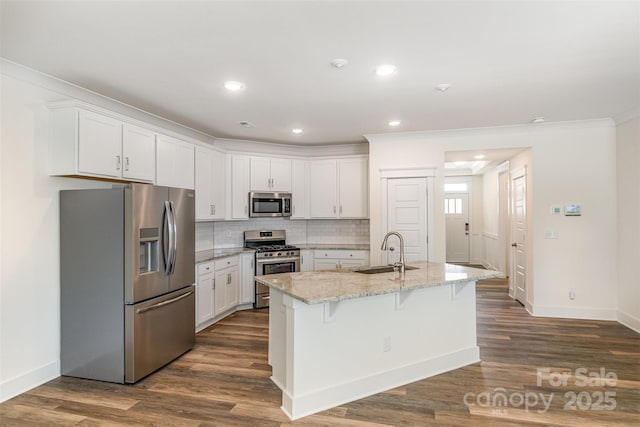 kitchen with crown molding, appliances with stainless steel finishes, white cabinets, and a sink