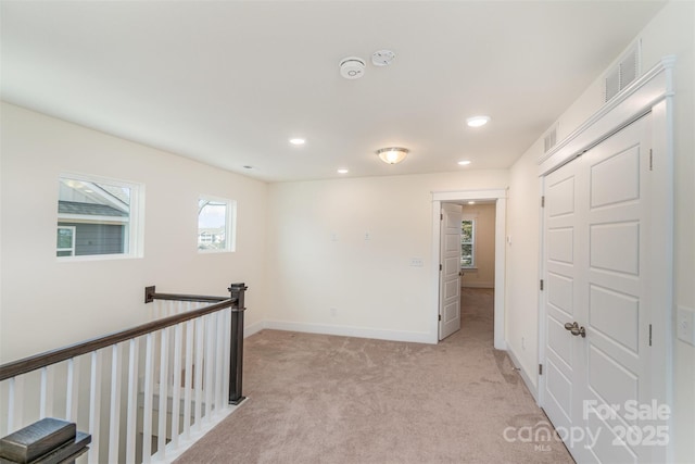 interior space with light carpet, recessed lighting, visible vents, and baseboards