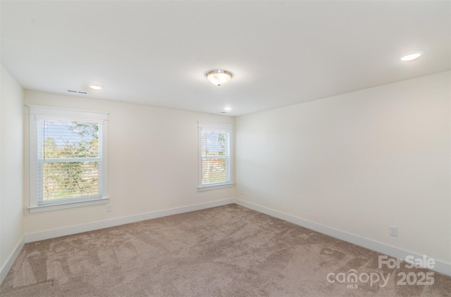 carpeted spare room featuring visible vents, baseboards, and recessed lighting