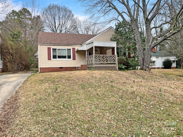 view of front facade with crawl space, roof with shingles, and a front yard