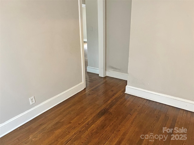 empty room featuring wood-type flooring and baseboards