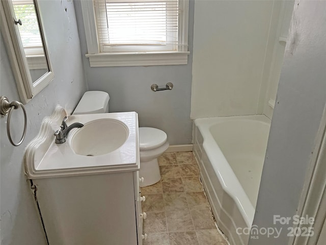 bathroom featuring vanity, toilet, and baseboards