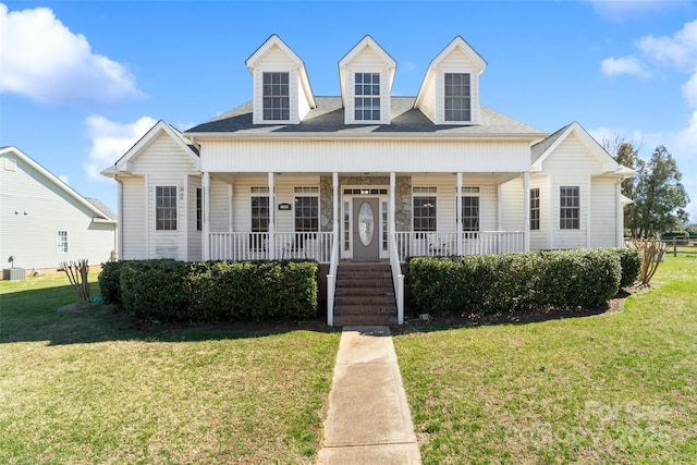 view of front of property with covered porch, a front lawn, and roof with shingles