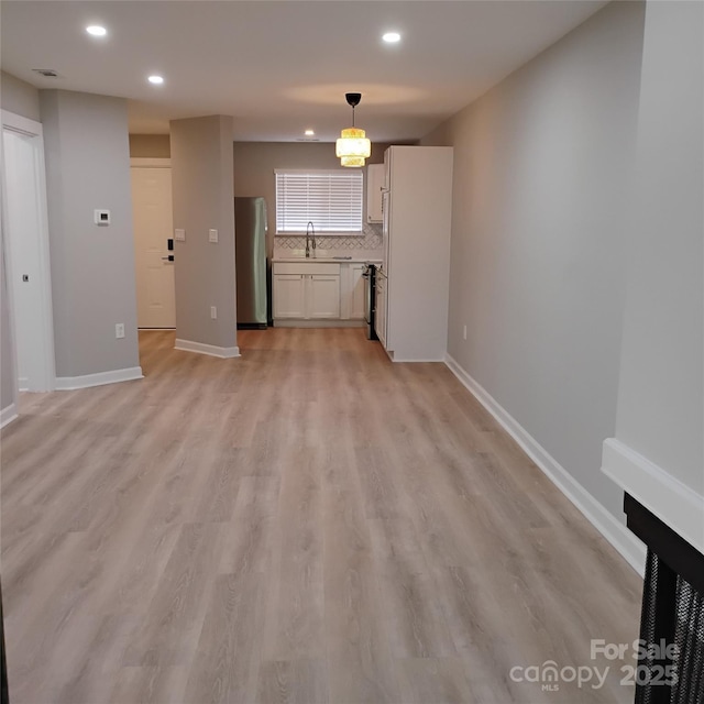 2545 Stockbridge Dr, Charlotte, NC 28210 - unfurnished living room featuring recessed lighting, baseboards, light wood finished floors, and a sink