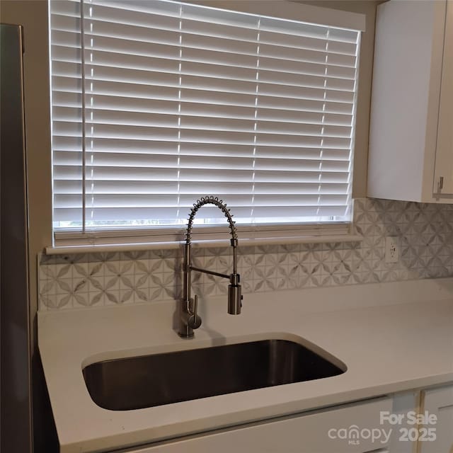 2545 Stockbridge Dr, Charlotte, NC 28210 - kitchen view of a sink, light countertops, decorative backsplash, and white cabinets