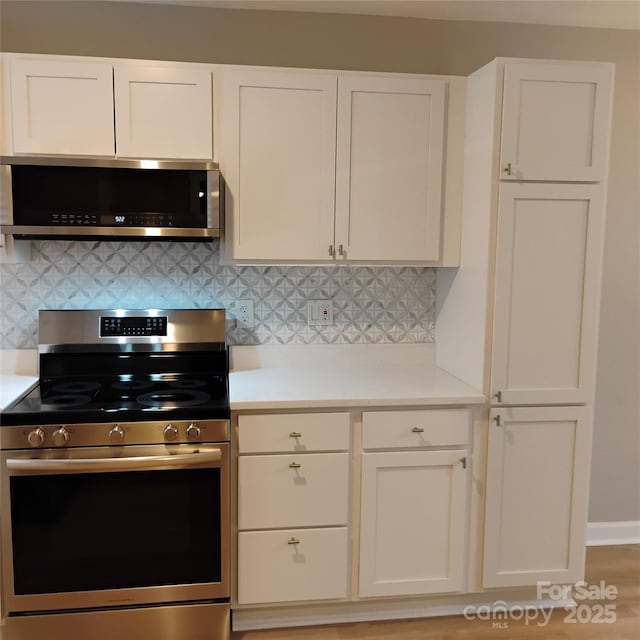 2545 Stockbridge Dr, Charlotte, NC 28210 - kitchen featuring stainless steel appliances, light countertops, white cabinetry, and decorative backsplash