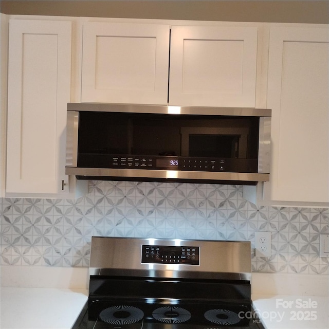 2545 Stockbridge Dr, Charlotte, NC 28210 - kitchen view of appliances with stainless steel finishes, decorative backsplash, white cabinets, and light countertops