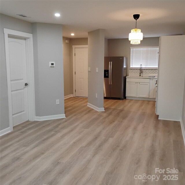 2545 Stockbridge Dr, Charlotte, NC 28210 - kitchen with stainless steel fridge, recessed lighting, white cabinets, light wood finished floors, and tasteful backsplash