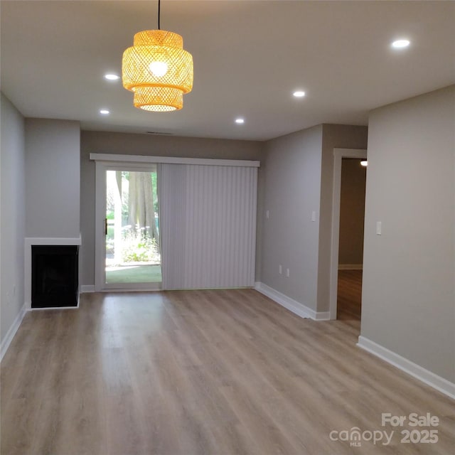 2545 Stockbridge Dr, Charlotte, NC 28210 - unfurnished living room featuring recessed lighting, baseboards, light wood-style flooring, and a fireplace