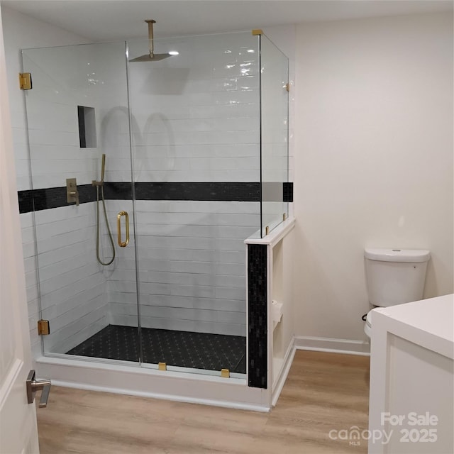 2545 Stockbridge Dr, Charlotte, NC 28210 - bathroom featuring wood finished floors, a shower stall, vanity, toilet, and baseboards