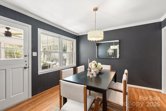 dining space with light wood-style flooring, baseboards, and ornamental molding