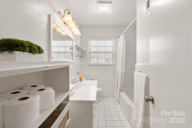 bathroom with vanity, visible vents, tile patterned flooring, tile walls, and toilet