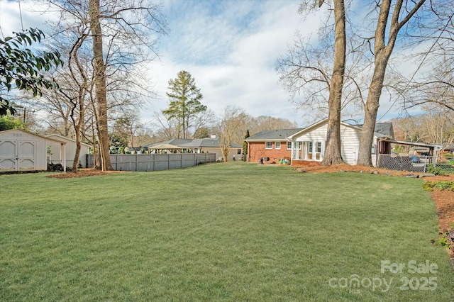 view of yard with a storage shed, an outdoor structure, and fence