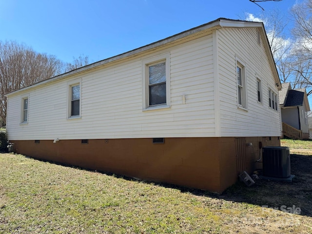 view of side of home with crawl space, central AC unit, and a yard