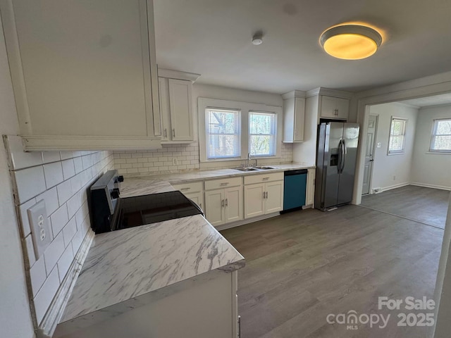 kitchen with dishwashing machine, electric range, a sink, light countertops, and stainless steel fridge