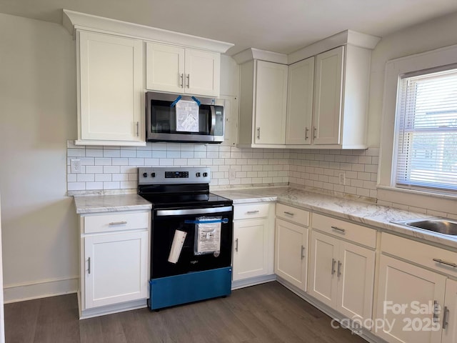 kitchen featuring white cabinetry, appliances with stainless steel finishes, backsplash, and dark wood-style flooring