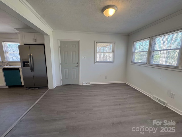 interior space featuring a textured ceiling, dark wood-style flooring, a sink, visible vents, and crown molding