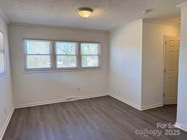 spare room with dark wood-style floors, a textured ceiling, visible vents, and crown molding