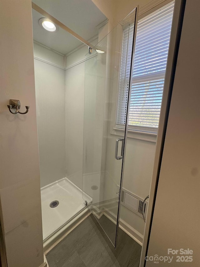 bathroom with a shower stall and visible vents