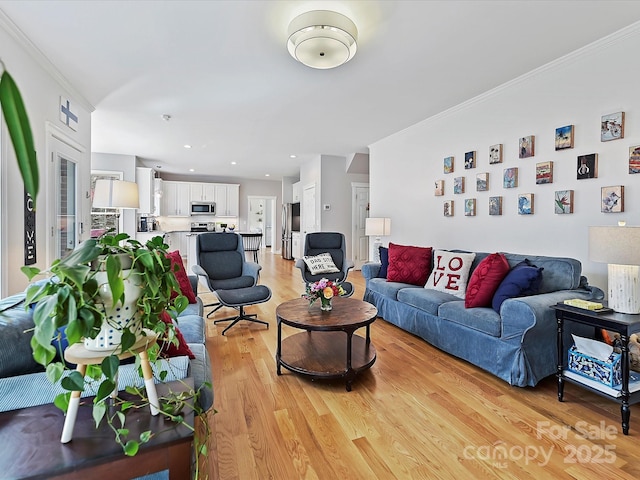 living room featuring ornamental molding, light wood-style flooring, and recessed lighting