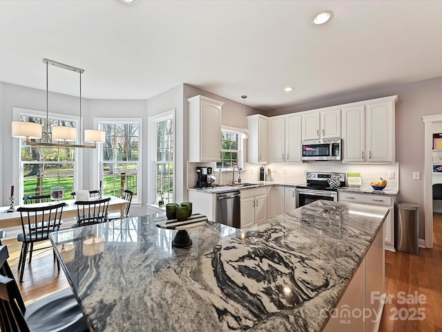 kitchen featuring appliances with stainless steel finishes, light stone countertops, and tasteful backsplash