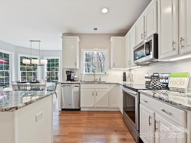 kitchen with stainless steel appliances, white cabinets, and a sink