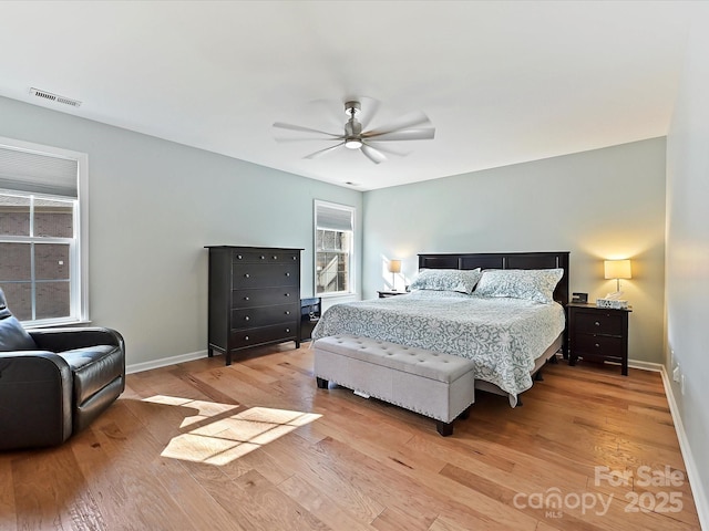 bedroom with light wood finished floors, a ceiling fan, and baseboards