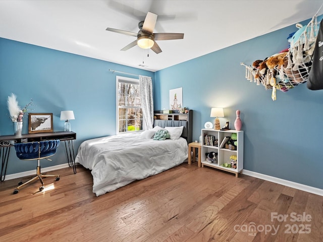 bedroom featuring ceiling fan, baseboards, and wood finished floors