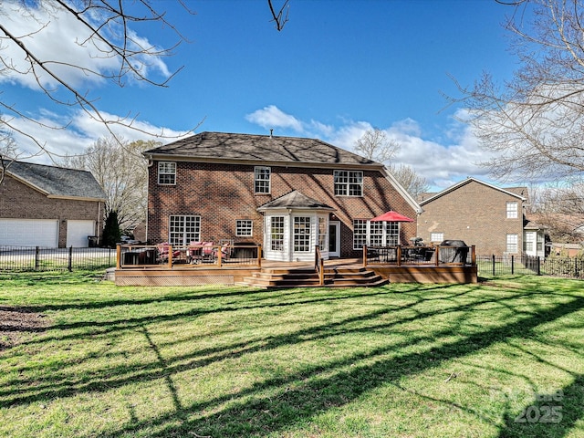 rear view of house with a yard, brick siding, fence, and a wooden deck