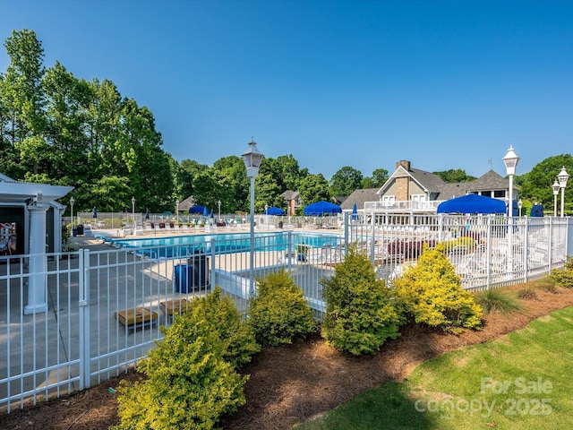 community pool featuring fence and a patio