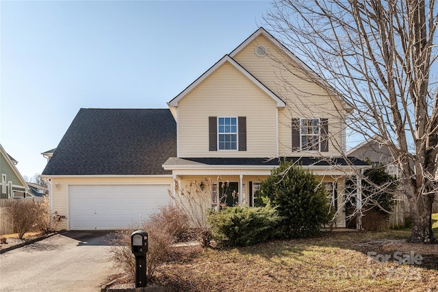 traditional home featuring driveway, a garage, and roof with shingles