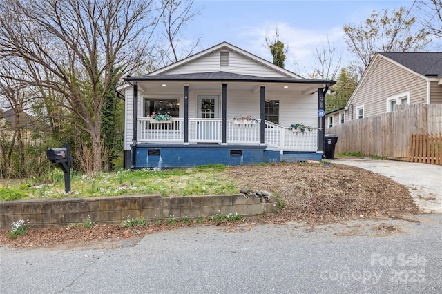 view of front of property featuring covered porch and fence