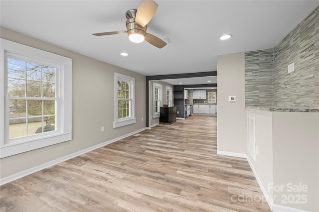 unfurnished living room with baseboards, ceiling fan, light wood-style flooring, and recessed lighting