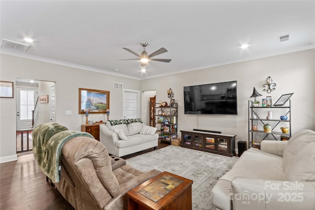 living room with visible vents, dark wood finished floors, and crown molding