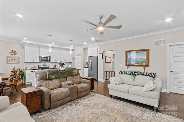 living area with visible vents, baseboards, dark wood-style floors, and crown molding