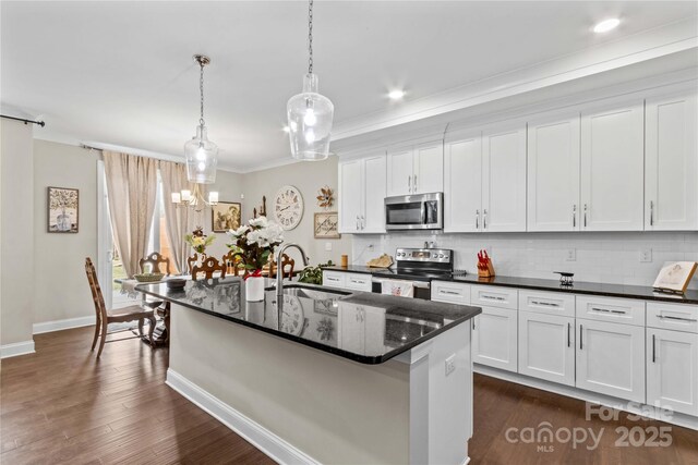 kitchen with a sink, stainless steel appliances, tasteful backsplash, and white cabinets