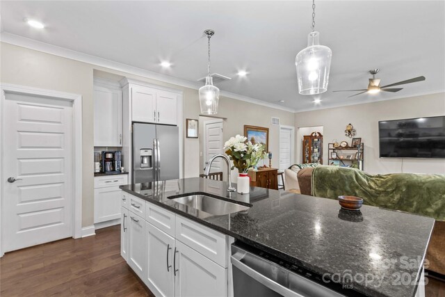 kitchen with dark wood-type flooring, an island with sink, ornamental molding, stainless steel refrigerator with ice dispenser, and a sink