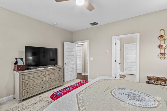 bedroom featuring a ceiling fan, baseboards, visible vents, and light colored carpet