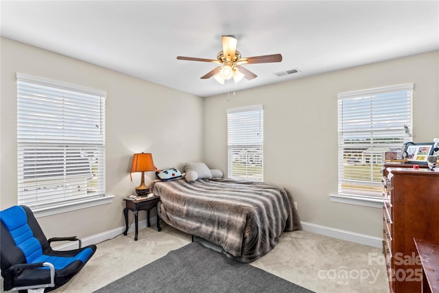 carpeted bedroom featuring visible vents, multiple windows, and baseboards