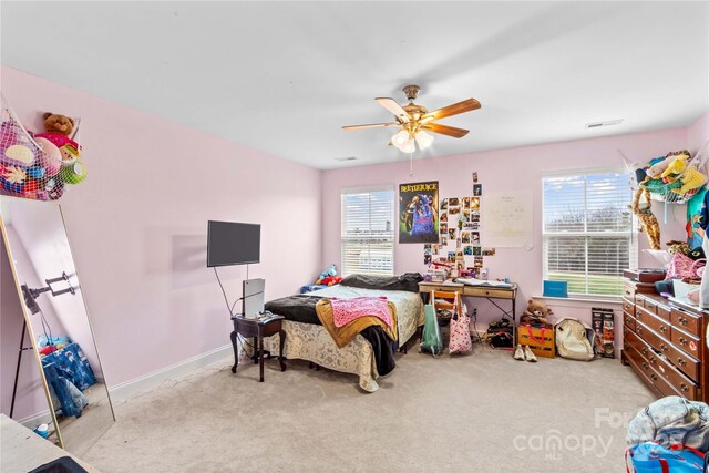 bedroom with multiple windows, baseboards, ceiling fan, and carpet floors