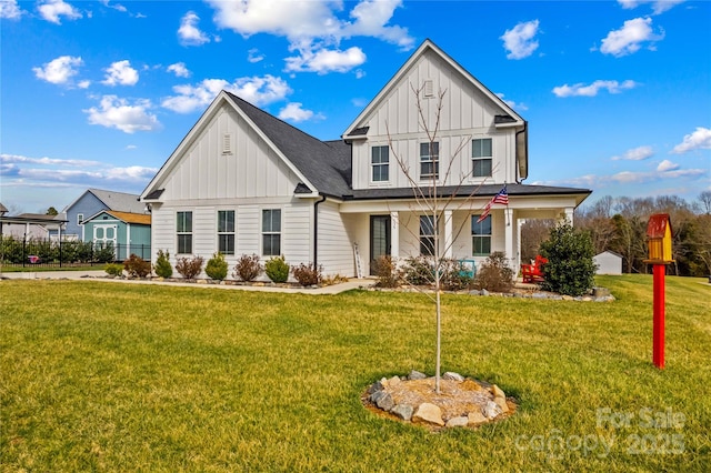 view of front of house featuring a front lawn, board and batten siding, and a shingled roof